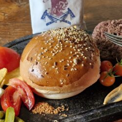 Pain à burger fait maison entouré d'ingrédients frais pour la préparation d'un burger gourmand