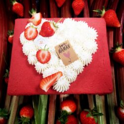 gâteau fête des mères rouge avec des fraises sur un lit de côtes de rhubarbe