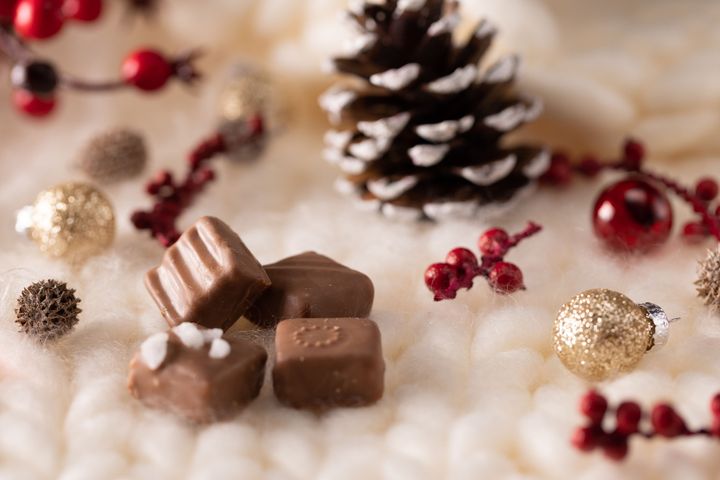 Coffret de chocolats artisanaux de la Maison Gélis présenté dans une ambiance de Noël avec des décorations festives.