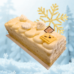 Bûche glacée L’Aube de La Maison Gélis, associant sorbet citron, glace vanille et biscuit à l’huile d’olive, décorée d’un flocon doré, présentée dans un décor hivernal lumineux.