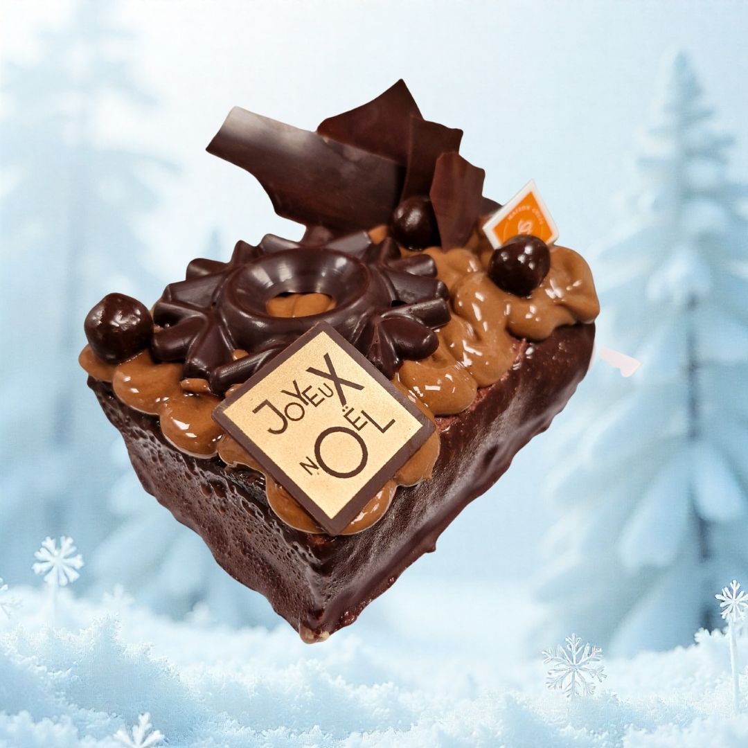 bûche Crépuscule de la Maison Gélis, au chocolat noir et à la mûre, décorée de volutes de chocolat et de perles croustillantes sur un glaçage sombre.